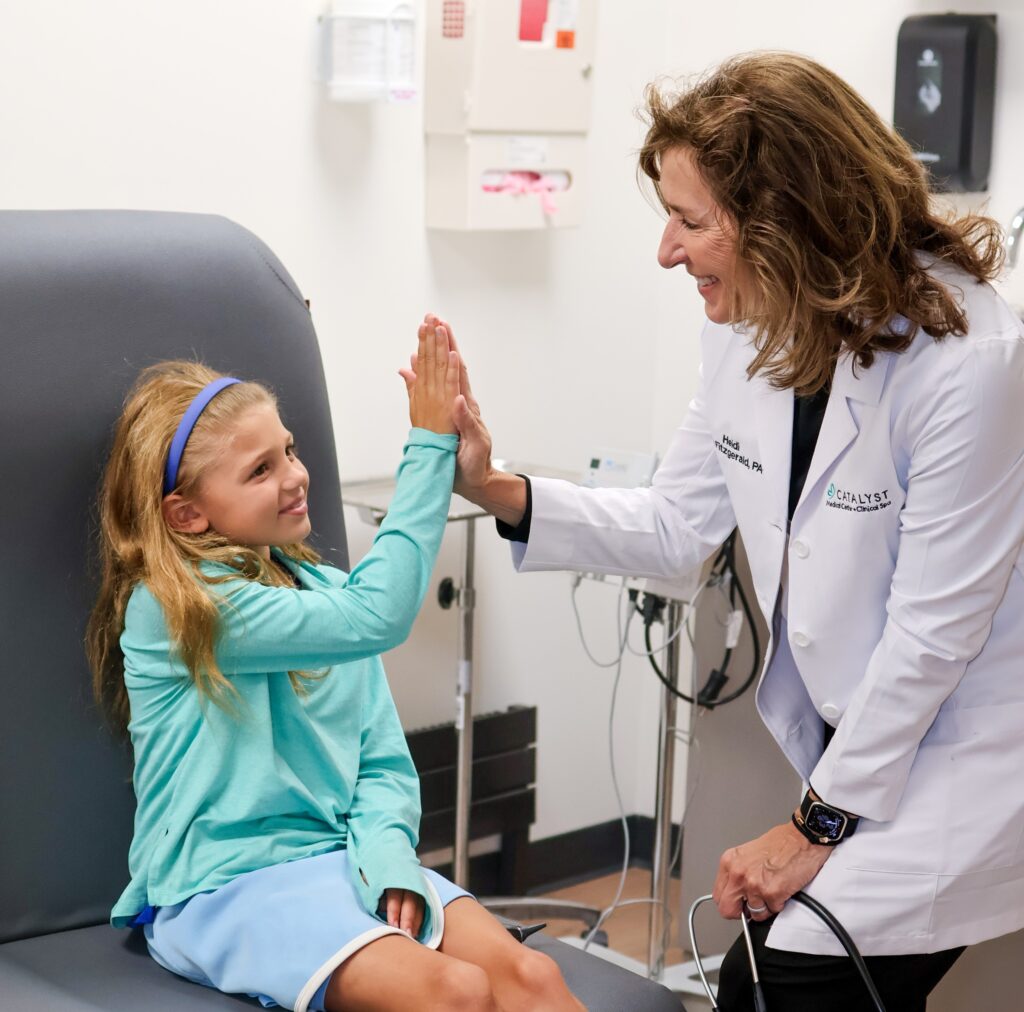 Family medicine provider high fiving a young patient at Catalyst Medical Center.