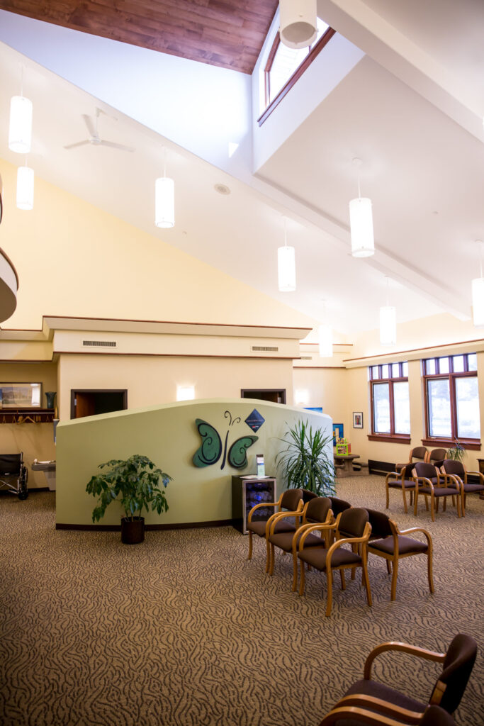 Waiting room at Catalyst Medical Center - several padded chairs in a large, open area with vaulted ceiling and bright, soft lighting.